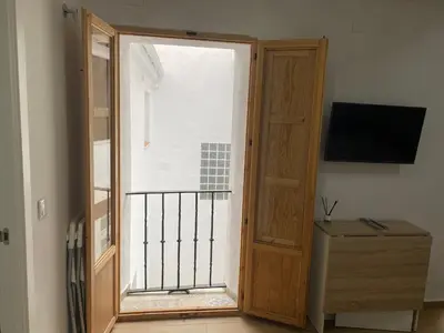 an open door to a balcony with a television at EL VENENCIADOR in Jerez de la Frontera