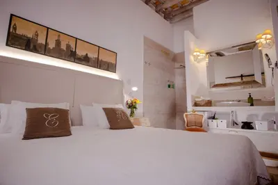 a bedroom with a large white bed and a sink at LalaSuites SHARIS in Jerez de la Frontera