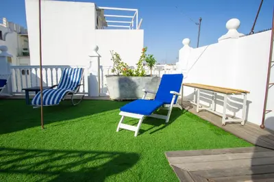 a patio with two chairs and a table on grass at LalaSuites SHARIS in Jerez de la Frontera
