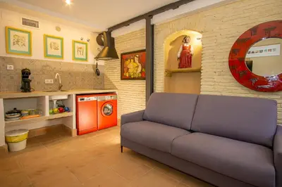 a living room with a couch and a kitchen at LalaSuites SHARIS in Jerez de la Frontera