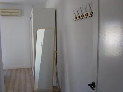 a mirror on a wall next to a white refrigerator at Apartamento Luz de Sanlúcar in Sanlúcar de Barrameda