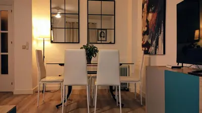a dining room with a table and white chairs at Apartamento Luz de Sanlúcar in Sanlúcar de Barrameda