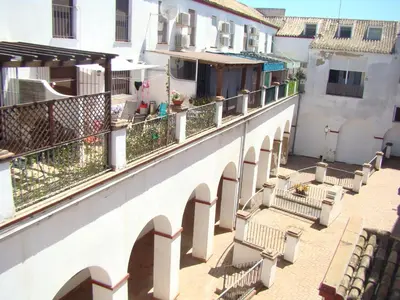 a balcony of a white building with chairs on it at Apartamento Luz de Sanlúcar in Sanlúcar de Barrameda