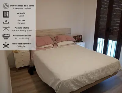 a bedroom with a large bed with white sheets and pink pillows at Apartamento Luz de Sanlúcar in Sanlúcar de Barrameda