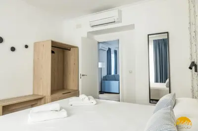 a bedroom with a white bed and a mirror at La Luz de la Viña - by Cadiz Time in Cádiz