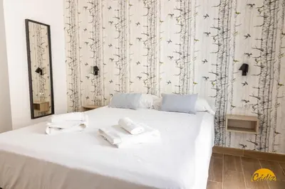 a bedroom with a white bed with towels on it at La Luz de la Viña - by Cadiz Time in Cádiz