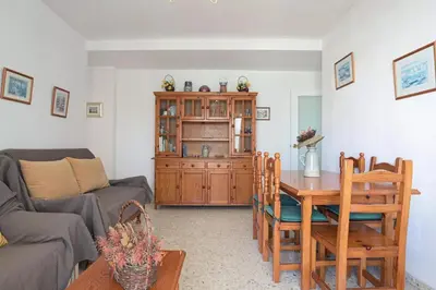 a living room with a table and a couch at Valdelagrana: primera línea de playa. in El Puerto de Santa María