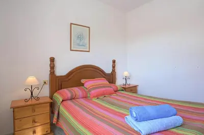 a bedroom with a bed with two towels on it at Valdelagrana: primera línea de playa. in El Puerto de Santa María