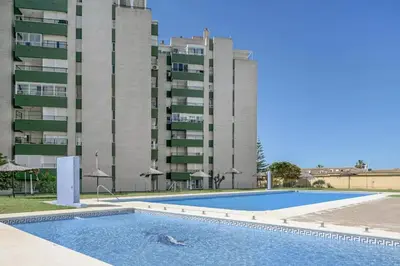 an empty swimming pool in front of a building at Valdelagrana: primera línea de playa. in El Puerto de Santa María
