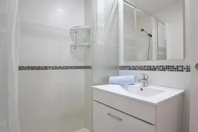 a white bathroom with a sink and a shower at Valdelagrana: primera línea de playa. in El Puerto de Santa María