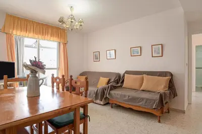 a living room with a couch and a table at Valdelagrana: primera línea de playa. in El Puerto de Santa María