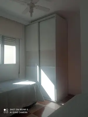 an empty bedroom with a bed and a window at Apartamento grumete in El Puerto de Santa María
