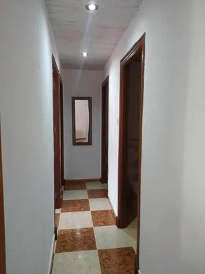 a hallway with a tile floor and a mirror at Apartamento grumete in El Puerto de Santa María