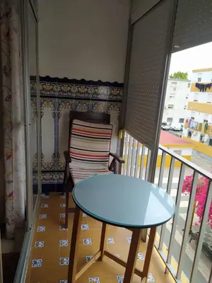 a table and a chair on a balcony at Apartamento grumete in El Puerto de Santa María