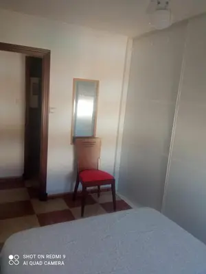 a bedroom with a red chair and a mirror at Apartamento grumete in El Puerto de Santa María