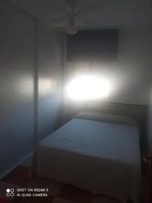 a bedroom with a bed and a light on the wall at Apartamento grumete in El Puerto de Santa María