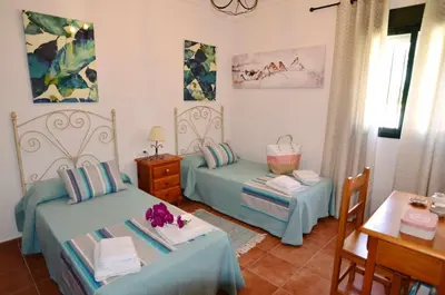 a room with two beds and a table and a table at Chalet Roche (Conil) | Alquileres Atardecer in Roche