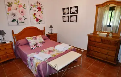 a bedroom with a bed with a dresser and a mirror at Chalet Roche (Conil) | Alquileres Atardecer in Roche