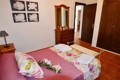 a bedroom with a purple bed with flowers on it at Chalet Roche (Conil) | Alquileres Atardecer in Roche