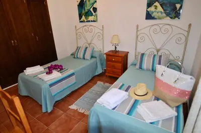 a bedroom with two beds and a table and chairs at Chalet Roche (Conil) | Alquileres Atardecer in Roche