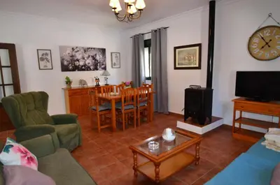 a living room with a couch and a table and a clock at Chalet Roche (Conil) | Alquileres Atardecer in Roche