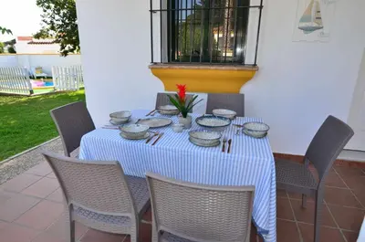 a table with bowls and plates on top of it at Chalet Roche (Conil) | Alquileres Atardecer in Roche