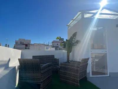 a plant on the side of a building with the sun shining at Hidden Gem Penthouse El Mesón in Cádiz