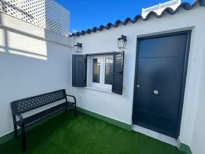 a bench sitting next to a building with a door at Hidden Gem Penthouse El Mesón in Cádiz