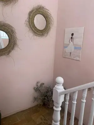 a staircase with two wreaths and a picture on a wall at Patios del Agua in El Puerto de Santa María