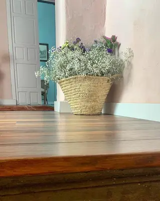 a basket filled with flowers sitting on a wooden floor at Patios del Agua in El Puerto de Santa María