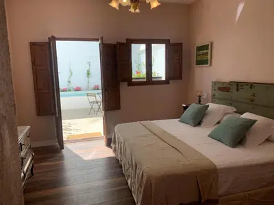 a bedroom with a large bed and a large window at Patios del Agua in El Puerto de Santa María