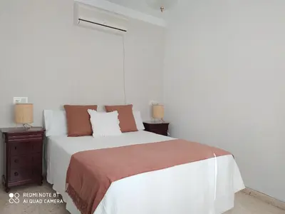 a bedroom with a large bed and two night stands at Casa playa Bajo de Guía-Centro in Sanlúcar de Barrameda