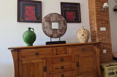 two vases and a mirror on a wooden dresser at La Casita de Guía by Sanlúcar Housing in Sanlúcar de Barrameda