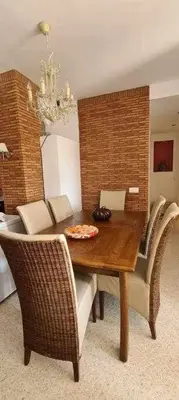 a dining room with a wooden table and chairs at La Casita de Guía by Sanlúcar Housing in Sanlúcar de Barrameda