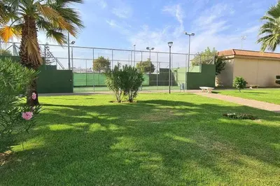 a park with a fence and a bench in the grass at La Casita de Guía by Sanlúcar Housing in Sanlúcar de Barrameda