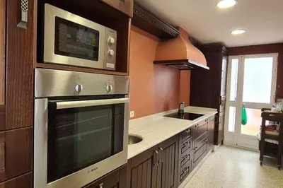 a kitchen with a stainless steel oven and a sink at La Casita de Guía by Sanlúcar Housing in Sanlúcar de Barrameda