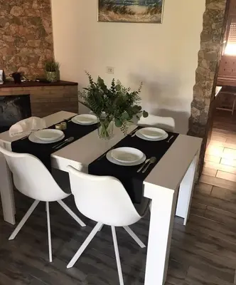 a dining table with white chairs and a black and white table at las camelias in El Puerto de Santa María