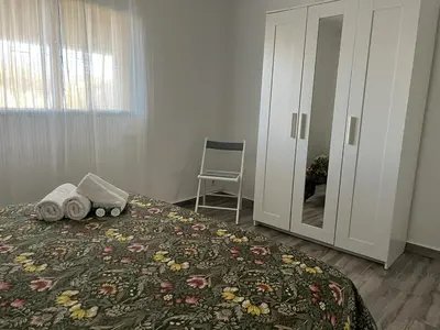 a bedroom with a bed with a dresser and a chair at las camelias in El Puerto de Santa María