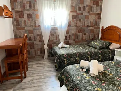 a hotel room with two beds and a desk at las camelias in El Puerto de Santa María
