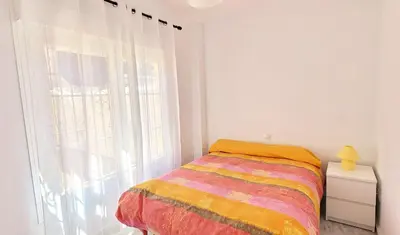a bedroom with a bed and a large window at Casa Playa de Valdelagrana in El Puerto de Santa María