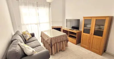a living room with a couch and a television at Casa Playa de Valdelagrana in El Puerto de Santa María