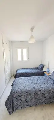 a bedroom with two beds with blue comforters at Casa Playa de Valdelagrana in El Puerto de Santa María