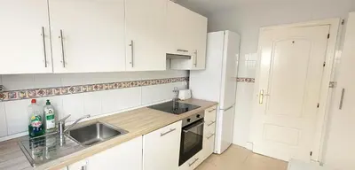 a kitchen with white cabinets and a sink at Casa Playa de Valdelagrana in El Puerto de Santa María