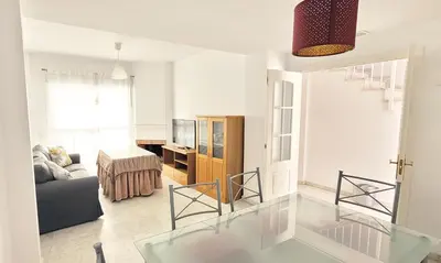 a living room with a glass table and a couch at Casa Playa de Valdelagrana in El Puerto de Santa María