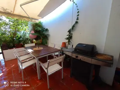 a dining room with a table and chairs and a grill at Casa en Loma Sancti Petri a 900 m de la playa de La Barrosa in Chiclana de la Frontera