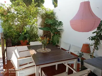 a table and chairs in a room with plants at Casa en Loma Sancti Petri a 900 m de la playa de La Barrosa in Chiclana de la Frontera