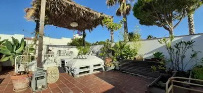 a patio with a white bed and some plants at Casa en Loma Sancti Petri a 900 m de la playa de La Barrosa in Chiclana de la Frontera
