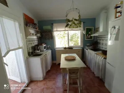 a kitchen with a table with a pizza on it at Casa en Loma Sancti Petri a 900 m de la playa de La Barrosa in Chiclana de la Frontera