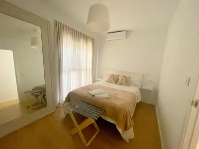 a bedroom with a bed with a chair and a window at Eva Recommends Francos in Jerez de la Frontera