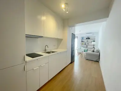 a kitchen with white cabinets and a wooden floor at Eva Recommends Francos in Jerez de la Frontera